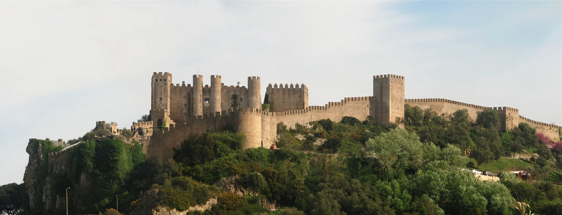 Pueblo medieval amurallado de Obidos con casas encaladas y flores de colores