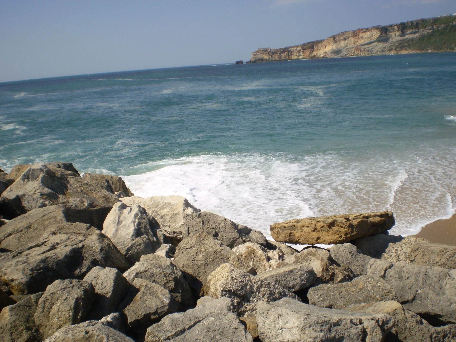 Nazaré coastal town in Portugal with dramatic cliffs, lighthouse, and Atlantic Ocean waves