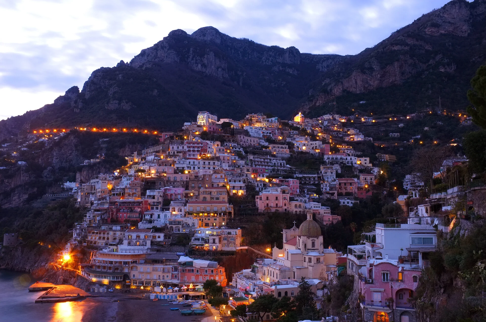 Positano village on the Amalfi Coast with pastel houses cascading down the cliff at sunset