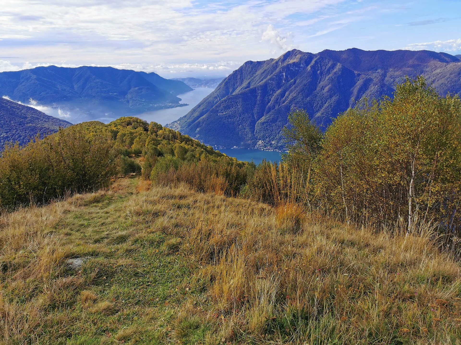Kayakistas remando por las aguas calmas del Lago Como con los Alpes elevándose al fondo