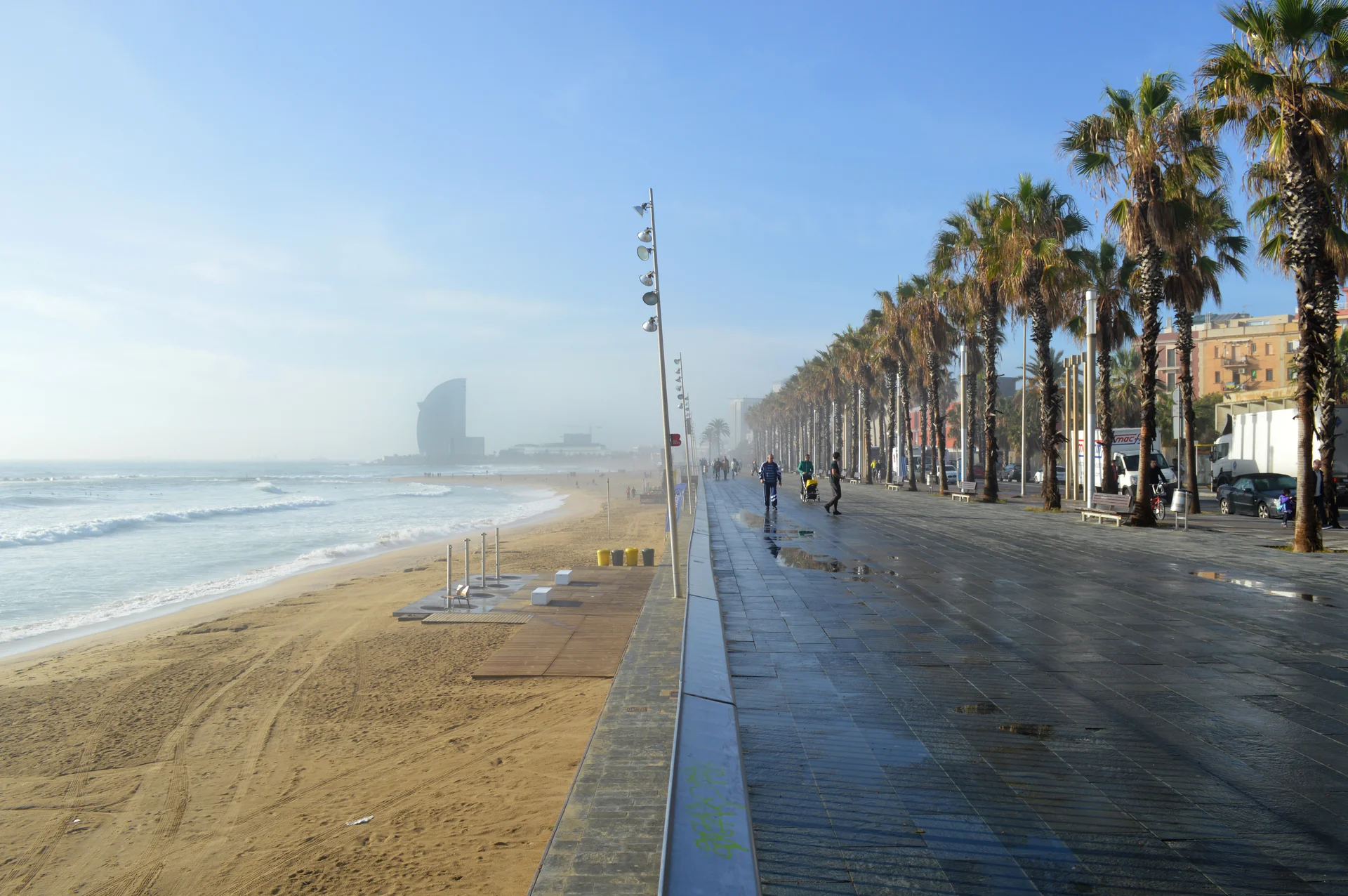 The palm-lined promenade and golden sand of Barceloneta beach in Barcelona