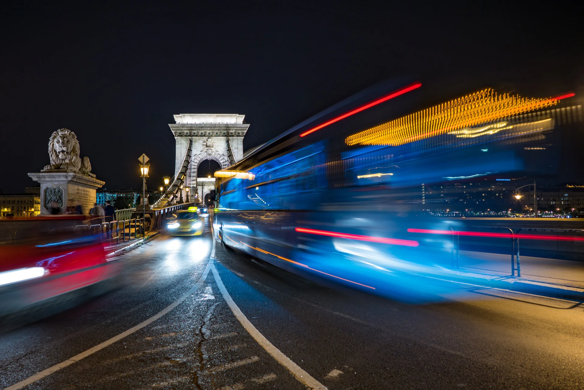 Ponte das Correntes em Budapeste iluminada a noite com o Castelo de Buda brilhando na colina atras