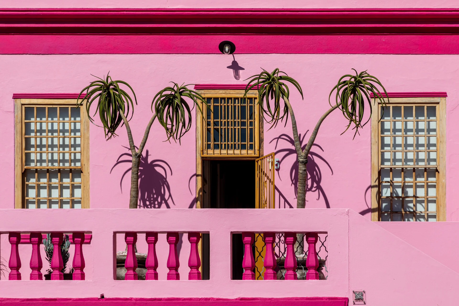 Colorful Bo-Kaap houses on a cobblestone street in Cape Town with Signal Hill in the background