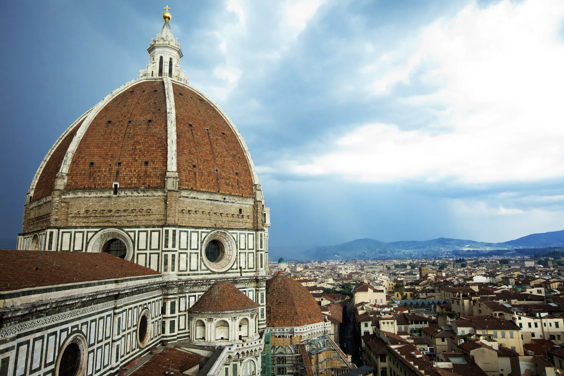 Brunelleschi's red-tiled dome on the Cathedral of Santa Maria del Fiore rising over the rooftops of Florence