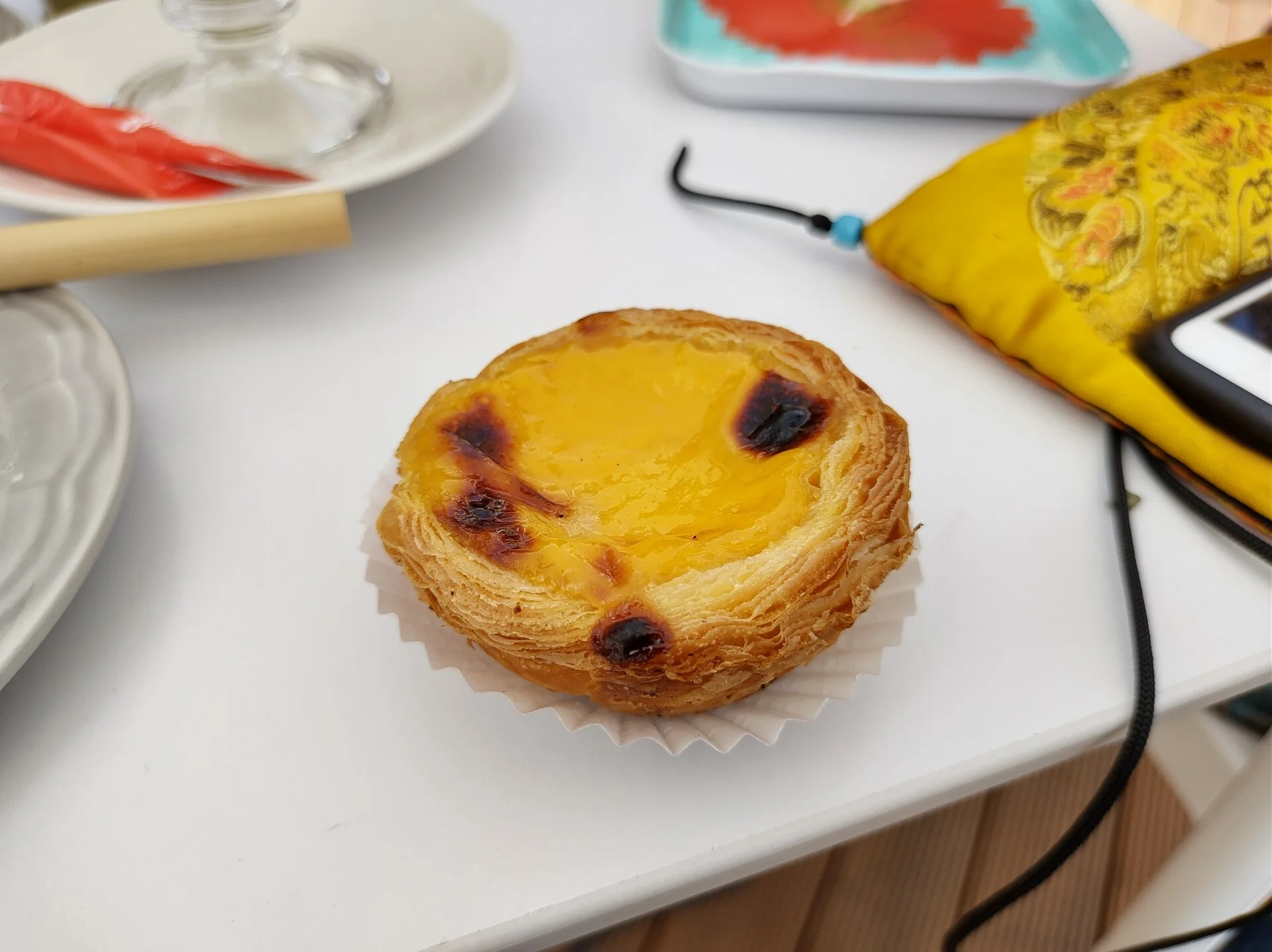 Pastéis de nata recém-saídos do forno com a parte superior caramelizada sobre uma grelha de resfriamento