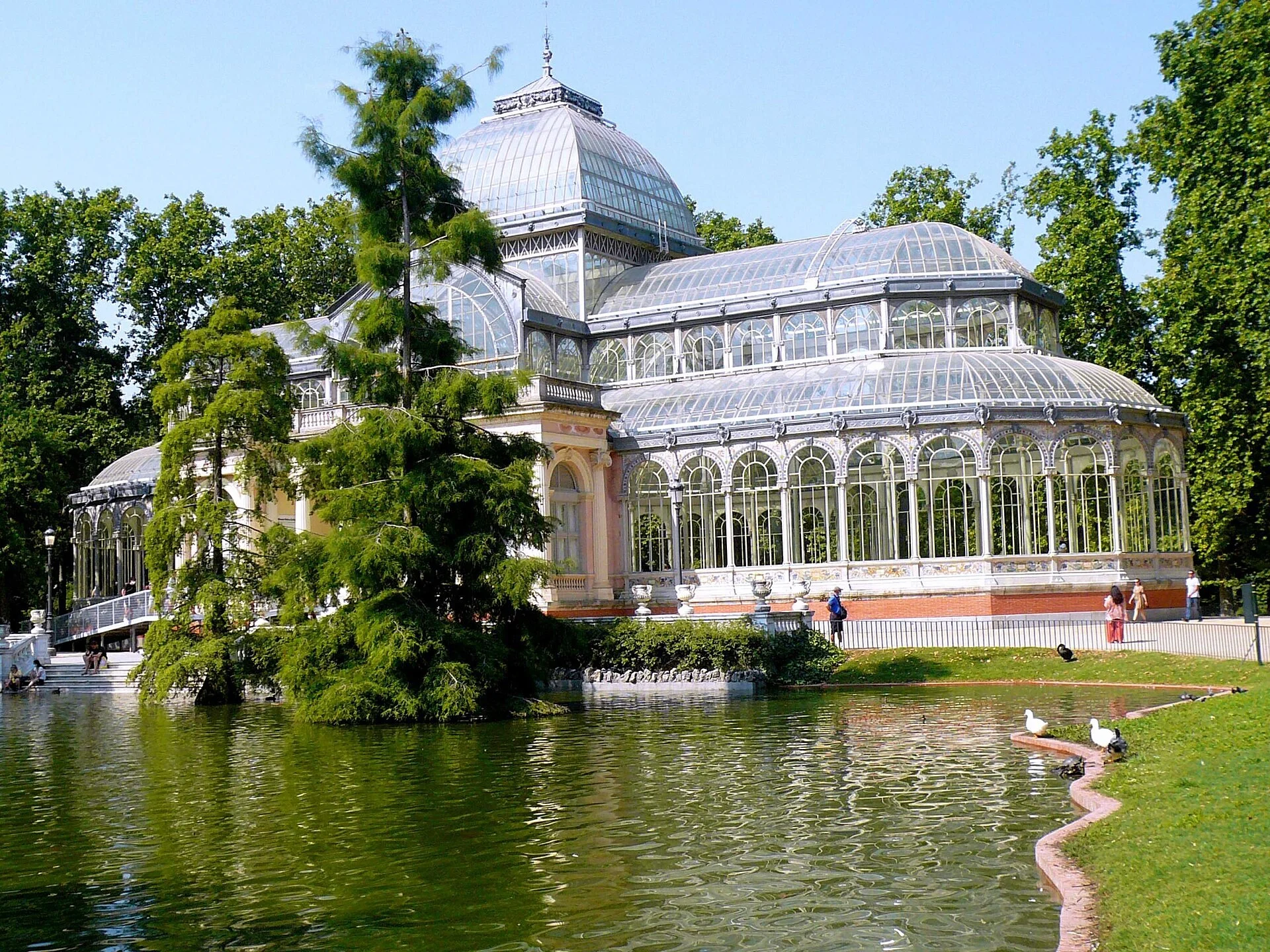 Der Glaspavillon Palacio de Cristal spiegelt sich in seinem Teich im Retiro-Park in Madrid