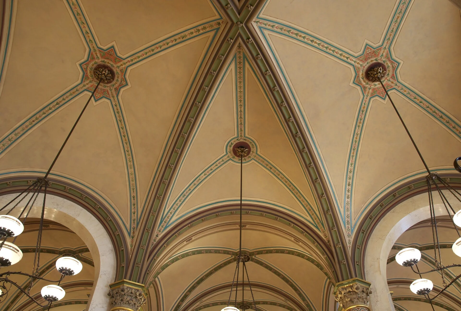 Interior de um cafe vienes tradicional com mesas de marmore, cadeiras de madeira curvada e luminarias elegantes