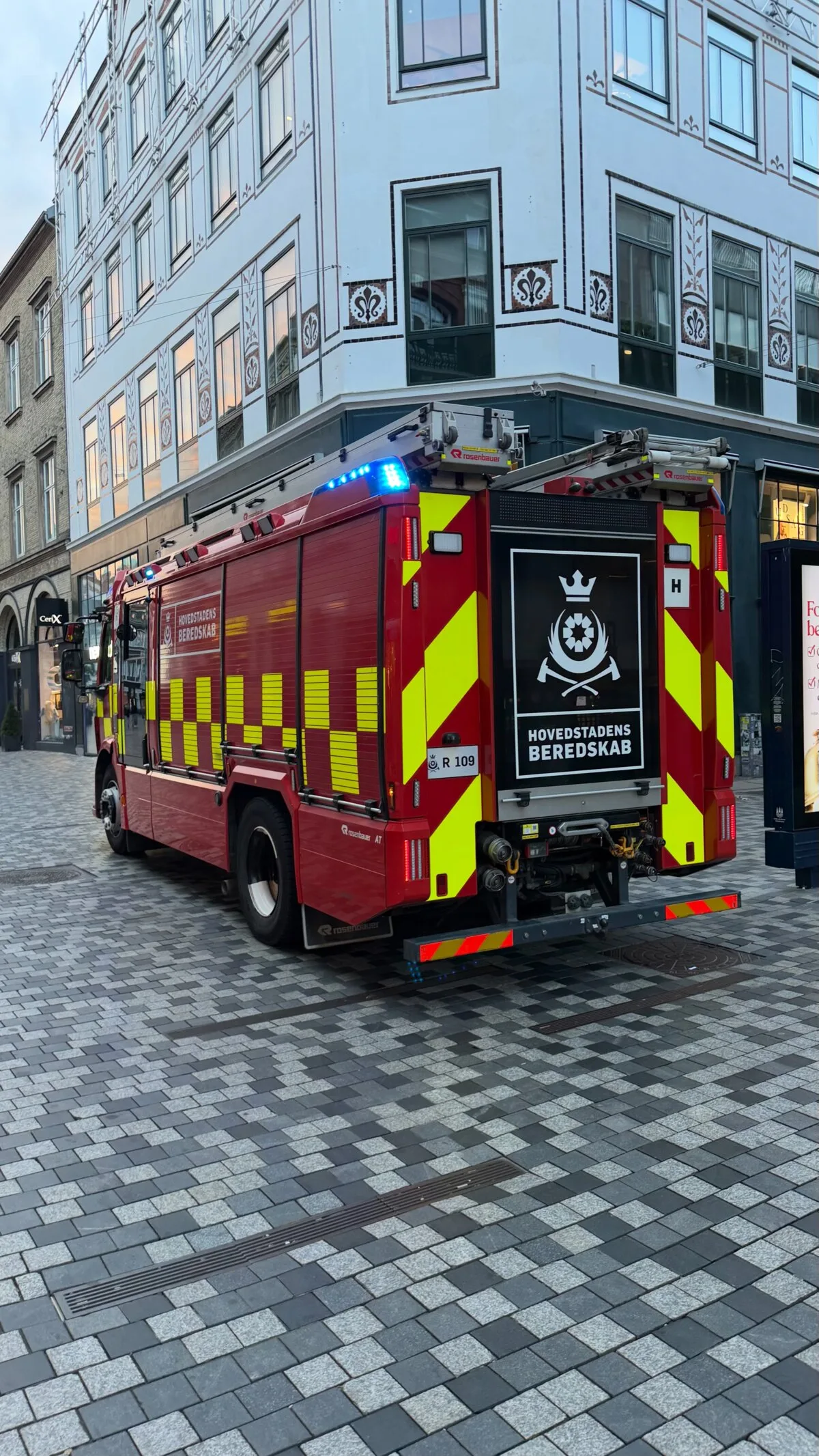 Copenhagen fire engine parked on a cobbled street after a false fire alarm at a rooftop restaurant