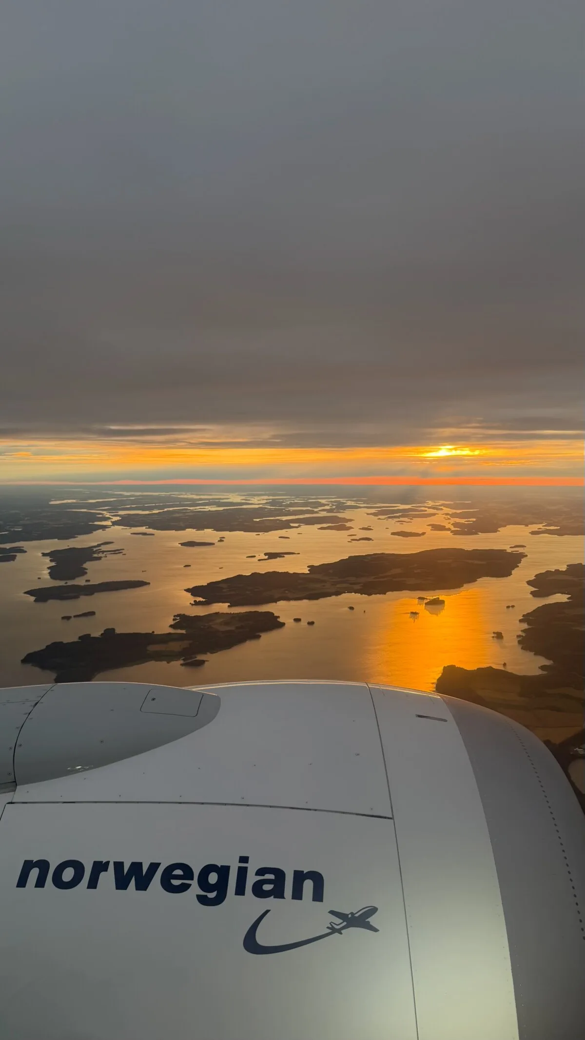 View from a Norwegian airplane window of the engine and the Stockholm archipelago at sunset