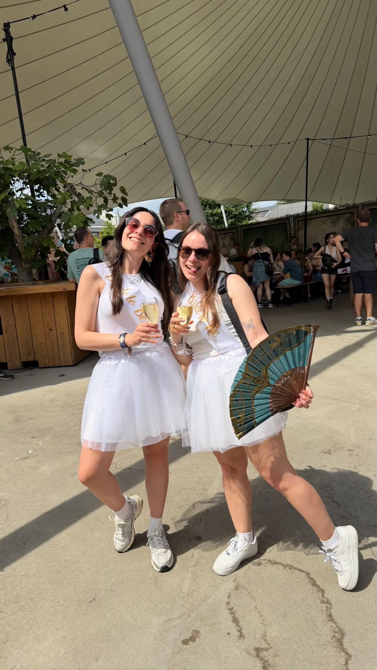 Two brides-to-be dressed in white at Tomorrowland 2026, celebrating a joint bachelorette party
