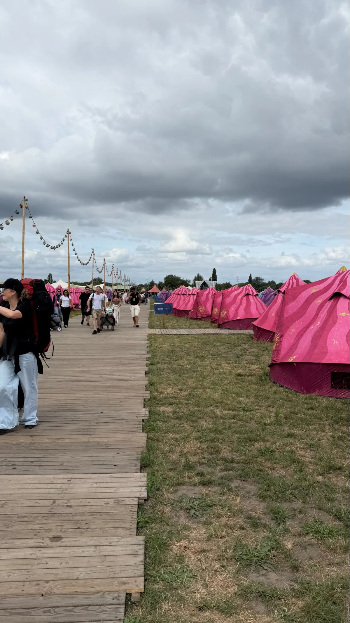Rows of pink Easy Tents along a wooden boardwalk in DreamVille, the Tomorrowland camping