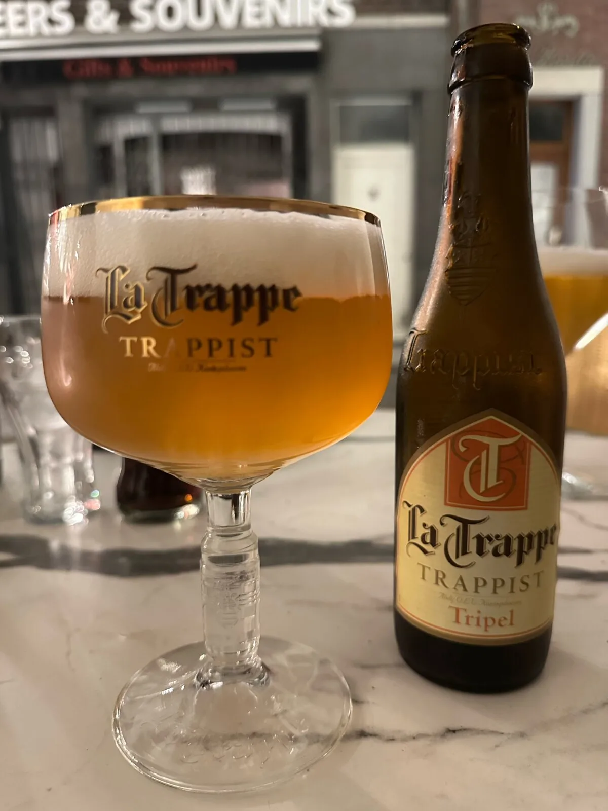 A La Trappe Trappist beer in its chalice glass next to the bottle at a bar in Antwerp